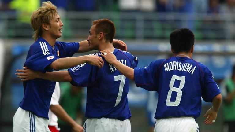 OSAKA - JUNE 14: Hidetoshi Nakata (no.7) of Japan celebrates scoring the second goal with team-mates Takayuki Suzuki (left) and Hiroaki Morishima (right) during the FIFA World Cup Finals 2002 Group H match between Japan and Tunisia played at the Osaka-Nagai Stadium, in Osaka, Japan on June 14, 2002. Japan won the match 2-0. DIGITAL IMAGE. (Photo by Alex Livesey/Getty Images)