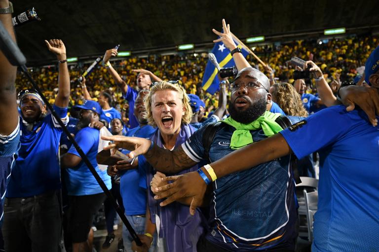 Curaçao fans celebrate World Cup 2026 qualification after a 0-0 draw with Jamaica at the National Stadium in Kingston, Jamaica on November 18, 2025. The tiny Caribbean nation of Curacao became the smallest country ever to qualify for the World Cup on November 18 as Haiti booked their return to the tournament for the first time in 52 years along with Panama.
A nerve-shredding finale to the CONCACAF qualifying campaign saw Curacao -- with a population of just 156,000 -- squeeze into next year's finals in the United States, Canada and Mexico with a 0-0 draw against Jamaica in Kingston. (Photo by Ricardo MAKYN / AFP) (Photo by RICARDO MAKYN/AFP via Getty Images)