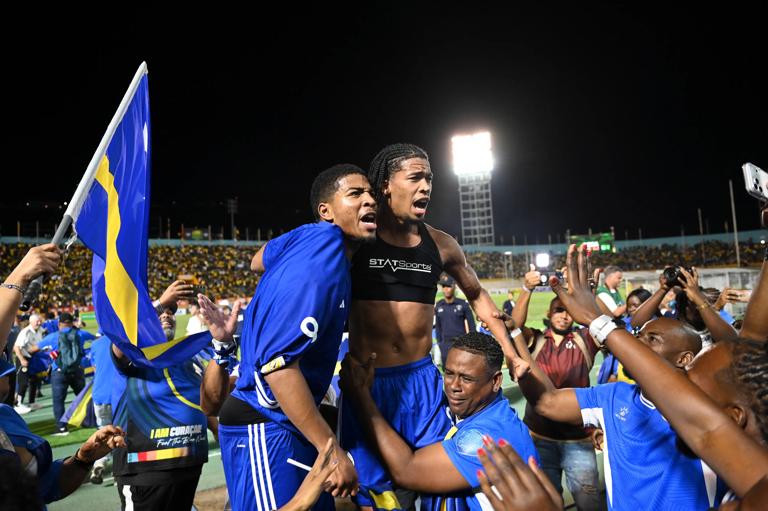 Curaçao players and fans celebrate World Cup 2026 qualification after a 0-0 draw with Jamaica at the National Stadium in Kingston, Jamaica on November 18, 2025. The tiny Caribbean nation of Curacao became the smallest country ever to qualify for the World Cup on November 18 as Haiti booked their return to the tournament for the first time in 52 years along with Panama.
A nerve-shredding finale to the CONCACAF qualifying campaign saw Curacao -- with a population of just 156,000 -- squeeze into next year's finals in the United States, Canada and Mexico with a 0-0 draw against Jamaica in Kingston. (Photo by Ricardo MAKYN / AFP) (Photo by RICARDO MAKYN/AFP via Getty Images)
