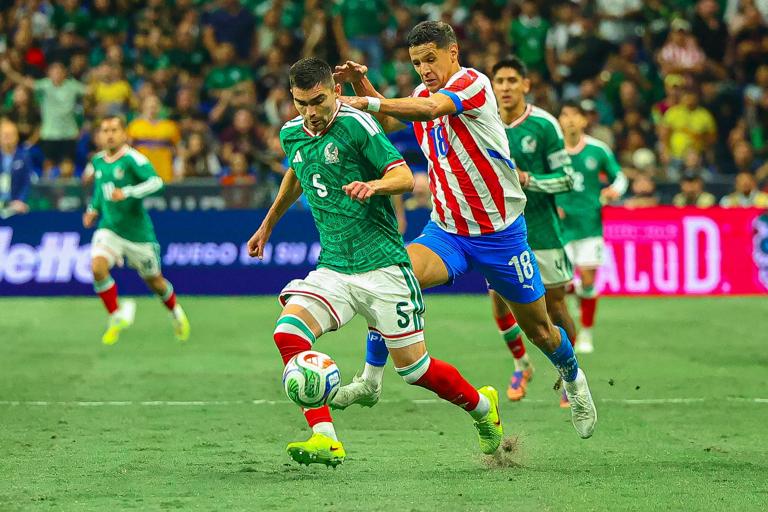 Johan Vásquez and Alex Arce contest possession in the match between Mexico and Paraguay